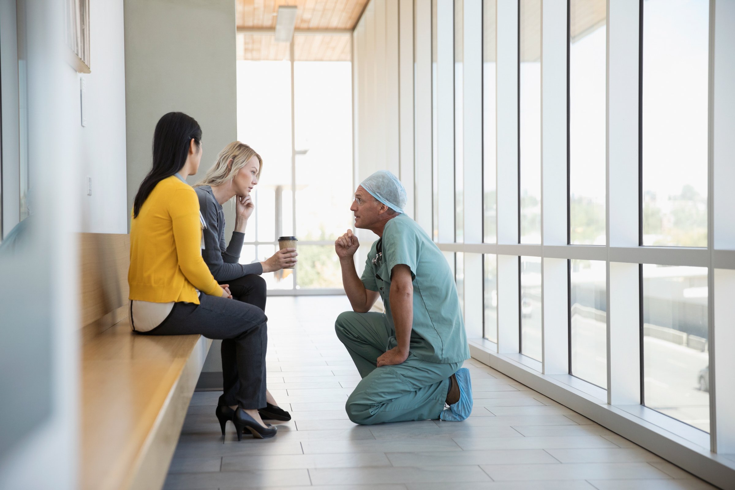 Attentive-surgeon-and-doctor-consoling-woman-in-hospital